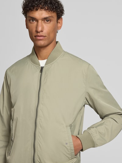 Männermodel trägt Regular Fit Bomberjacke mit Stehkragen von s.Oliver RED LABEL, unifarben, mit Reißverschluss, Nahaufnahme Oberkörper.