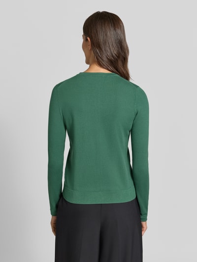 Vrouwenmodel draagt Regular Fit gebreid jack uit Viscosemix met geschulpte zoom van Christian Berg Woman, ruglengte maat S 56 cm, Mouwlengte maat S 61 cm, lange mouw, doorlopende knoopsluiting, ribboorden, egale groene kleur, gladde textuur, Dames, Ganzkörperaanzicht achteraan.
