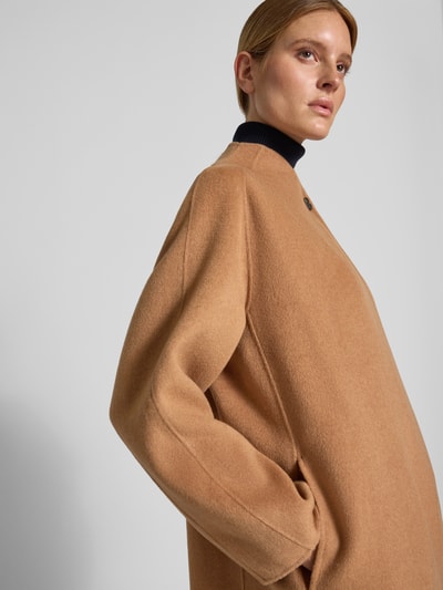 Vrouwenmodel draagt lange wollen jas met opstaande kraag en knoopsluiting van Style Icon Collection, effen camel, losse pasvorm, detailopname, Ruglengte maat 36: 124 cm, Schouderbreedte: 46 cm, Borstwijdte: 62 cm, Mouwlengte: 78 cm.