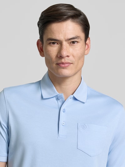 Männermodel trägt Regular Fit Poloshirt mit Brusttasche und Label-Stitching von bugatti in Hellblau, Knopfleiste, Nahaufnahme Oberkörper. Rückenlänge bei Größe M: 70 cm.