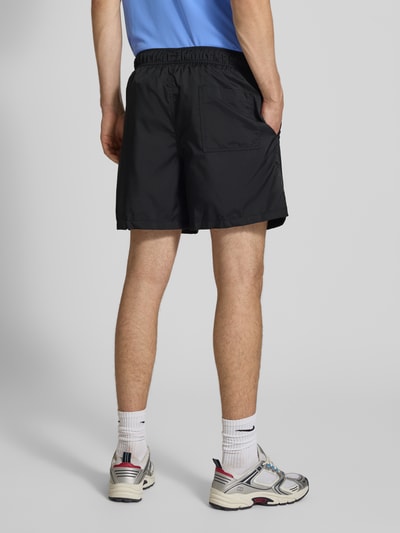 Männermodel trägt schwarze Shorts mit Label-Stitching und elastischem Bund von Nike, Regular-Fit, mit Tunnelzug, Ganzkörperansicht Rückansicht.