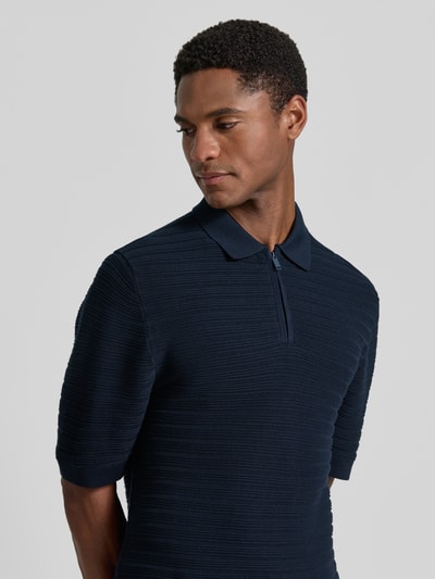 Männermodel trägt Regular Fit Poloshirt mit kurzem Reißverschluss von MCNEAL, Baumwoll-Mix mit Viskose-Anteil, Strukturmuster, Nahaufnahme Oberkörper.