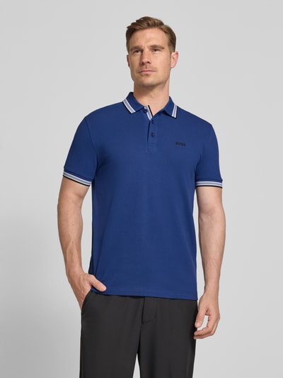 Männermodel trägt Regular Fit Poloshirt aus reiner Baumwolle Modell 'PADDY' von BOSS Green in Unifarbe Blau, Nahaufnahme Oberkörper