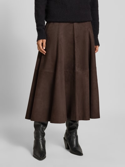Frauenmodel trägt Midirock aus echtem Leder Modell 'Kilar' von Cph Muse in Dunkelbraun, A-Linien-Form, Reißverschluss, Nahaufnahme Unterkörper, Bundweite 38 cm, Länge 84 cm.