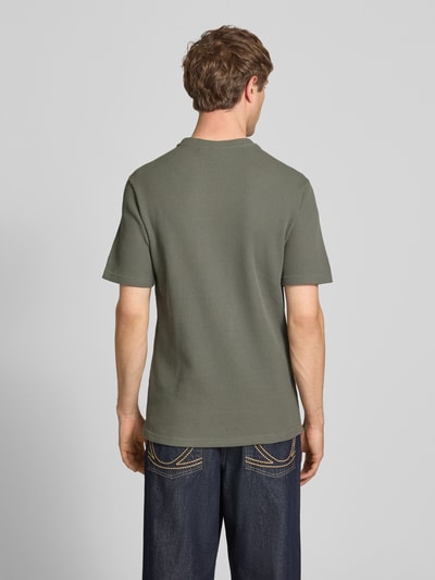 Männermodel trägt Regular Fit T-Shirt aus Baumwoll-Mix Modell 'TOBIE' von Only & Sons in Unifarbe mit Waffel-Struktur, Ganzkörperansicht Rückansicht.
