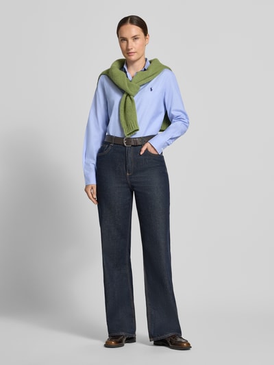 Frauenmodel trägt Regular Fit Hemdbluse aus reiner Baumwolle von Polo Ralph Lauren in Hellblau, kombiniert mit Jeans, Ganzkörperansicht von vorne. Damen Hemdbluse von Polo Ralph Lauren