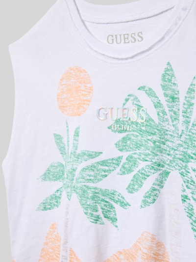 Mädchen trägt Regular Fit Top mit Logo-Applikation von Guess aus reiner Baumwolle mit Motiv-Print und Rundhalsausschnitt, Nahaufnahme Oberkörper.