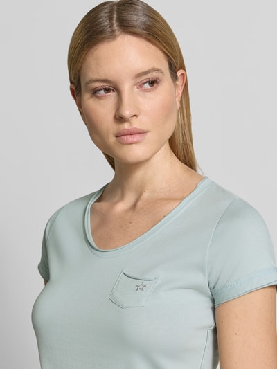 Kobiece model prezentuje damski t-shirt z bawełny krój regular fit G.I.G.A. DX, dekolt w serek, brustasza, model 'GS23', długość tyłu w rozmiarze 36: 64 cm, jasnoniebieski, gładka faktura, zbliżenie na górną część ciała