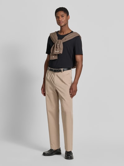 Männermodel trägt Loose Fit Bundfaltenhose mit Gesäßtaschen von MCNEAL aus Baumwoll-Elasthan-Mix in Beige, Ganzkörperansicht von vorne. Kontext: Herren Bundfaltenhose, Loose-Fit, 1er Bundfalte, Gesäßtaschen, Bundweite 45 cm, Innenbeinlänge 77 cm bei Größe 50.