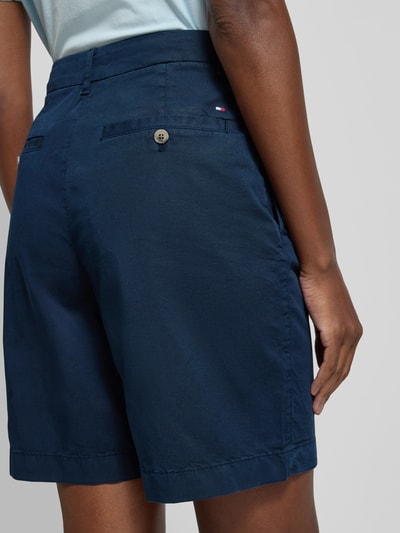 Vrouwenmodel draagt Regular Fit Chino-Shorts aus Baumwoll-Lyocell-Mix van Tommy Hilfiger, look: effen, mix van katoen en lyocell, gestikt logo, steekzakken, achterzakken, knoop- en ritssluiting. Detailopname achterkant.