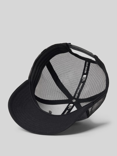 Produktfoto, zwarte Heren Trucker Cap met Labelpatch van The North Face, versterkte klep, verstelbare trensje, mesh en stof, binnenkant.