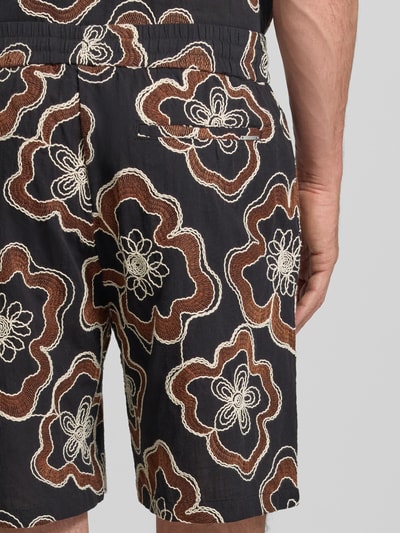 Mężczyznamodel prezentuje Straight Fit Shorts mit floralem Allover-Stitching od Antony Morato, czarny materiał, wzór kwiatowy, elastyczny pas ze sznurkiem, kieszeń z tyłu, bawełna, szerokość w rozmiarze 50: 45 cm, długość nogawki wewnętrznej w rozmiarze 50: 22 cm, detal z tyłu, zbliżenie