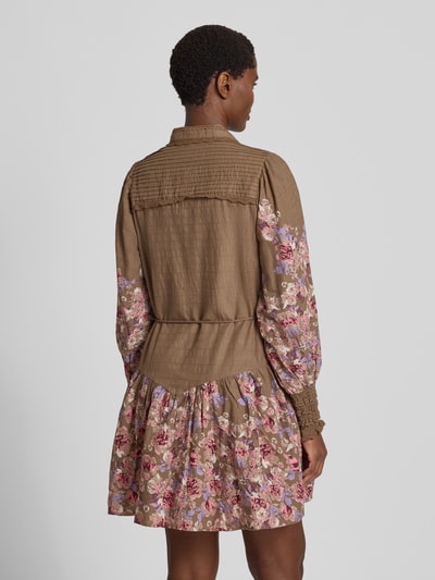 Frauenmodel trägt Hemdblusenkleid mit Bindegürtel Modell 'SOMELLU' von YAS, braun mit floralen Mustern, A-Linie, Rückenansicht, Kontext: Reine Baumwolle, Minikleid, Hemdblusenkragen, Knopfleiste, Bindegürtel, Rückenlänge 89 cm, Brustweite 50 cm, Ärmellänge 68 cm.