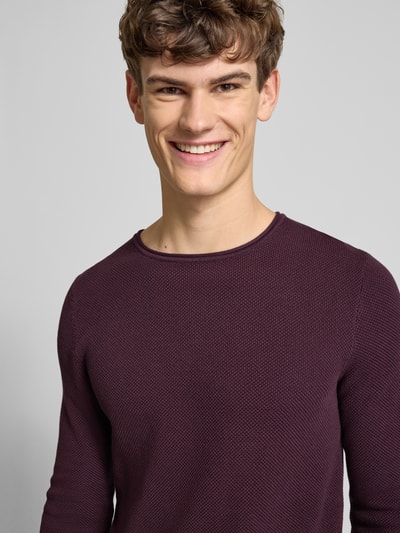 Männermodel trägt Basic Strickpullover mit Rundhalsausschnitt und Rollkanten von REVIEW in Dunkellila, reine Baumwolle, Nahaufnahme Oberkörper.