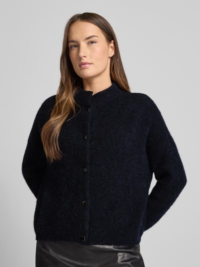 Frauenmodel trägt Regular Fit Strickjacke mit Alpaka-Anteil Modell 'Alpha' von Gestuz, dunkle Farbe, Stehkragen, Knopfleiste, elastischer Material-Mix, Ganzkörperansicht von vorne. Rückenlänge Größe S: 21 cm, Ärmellänge Größe S: 23 cm.