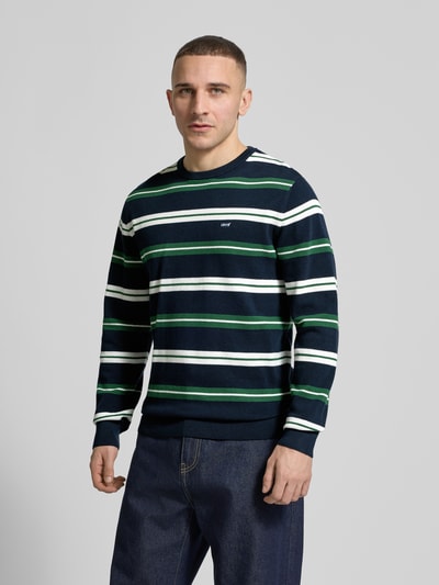 Männermodel trägt Regular Fit Sweatshirt aus reiner Baumwolle von Levi's®, Allover-Muster, Rundhals, langarm, Ganzkörperansicht von vorne.