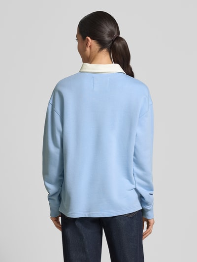 Frauenmodel trägt Longsleeve mit Polokragen und kurzer Knopfleiste von Gant in Hellblau, Baumwoll-Mix, Loose Fit, Rückenansicht.
