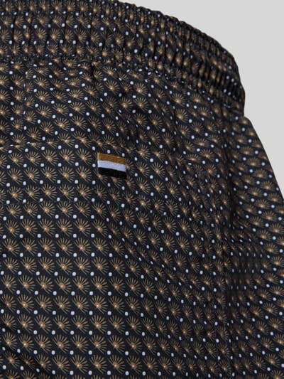 Produktfoto, Badeshorts mit Allover-Muster Modell 'VIBE' von BOSS in Schwarz-Braun mit elastischem Bund, Tunnelzug und Label Patch, Detailaufnahme.