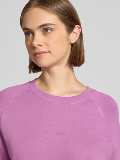 Frauenmodel trägt Regular Fit Sweatshirt aus reiner Baumwolle von Marc O'Polo DENIM in Lila, glatte Struktur, Nahaufnahme Oberkörper.