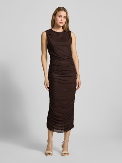 Frauenmodel trägt figurbetontes Maxikleid mit Rundhalsausschnitt Modell 'Corilina Solid' von Neo Noir in Braun, Material-Mix mit Stretch, seitliche Raffungen, Ganzkörperansicht von vorne.