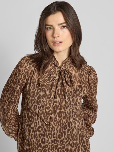 Kobiece model prezentuje bluzkę z wiązaniem pod szyją z bufiaste rękawy model 'Bettina' od JOOP!, luźny krój, stójka, brązowy nadruk w panterkę, długość tyłu w rozmiarze 36: 60 cm, długość rękawów w rozmiarze 36: 62 cm, zbliżenie na górną część ciała