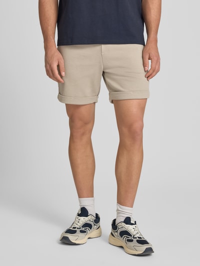 Männermodel trägt Regular Fit Shorts mit Viskose-Anteil Modell 'NEWKODYL' von Only & Sons in Melange-Optik, Nadelstreifen-Muster, Eingrifftaschen, fixierter Umschlag, elastischer Bundabschluss mit Tunnelzug, Gesäßtasche, Ganzkörperansicht von vorne.
