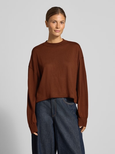 Vrouwenmodel draagt gebreide pullover van zuivere scheerwol, relaxed fit, model 'MALESE' van DRYKORN, bruine kleur, ronde hals, voorkant, ruglengte maat S 49 cm, mouwlengte maat S 52 cm, dames, detail: textuur effen knit, ganzekörperaanzicht van voren.