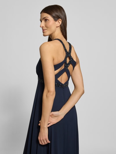 Frauenmodel trägt Regular Fit Abendkleid mit Rückenausschnitt von Jake*s Cocktail in Dunkelblau mit Ziersteinbesatz, Ganzkörperansicht Rückansicht.