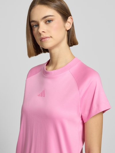 Frauenmodel trägt T-Shirt mit Logo und Rundhalsausschnitt von adidas Sportswear in Pink aus reiner Baumwolle, Regular-Fit, Nahaufnahme Oberkörper.