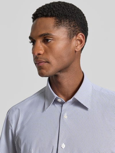 Männermodel trägt Regular Fit Businesshemd mit kurzem Arm Modell 'P-LIAM' von BOSS, Allover-Muster, Kentkragen, Nahaufnahme Oberkörper.