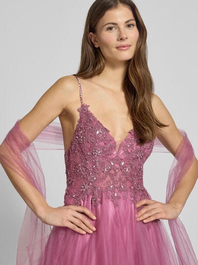 Frauenmodel trägt Abendkleid mit Ziersteinbesatz von Mascara in Lila mit Taillierter Passform, Tiefer V-Ausschnitt, Spaghettiträger, ausgestelltem Rockteil aus Tüll, Nahtreißverschluss, Maxilänge, Nahaufnahme Oberkörper.