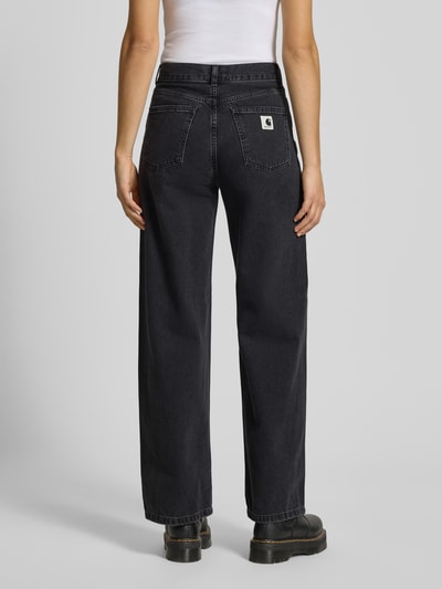 Vrouwenmodel draagt Jeans met wijd been model 'Jane' van Carhartt Work In Progress, zwarte denim, volledig uit katoen, achteraanzicht.