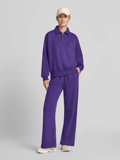 Frauenmodel trägt Wide Leg Sweathose aus Baumwoll-Mix mit Logo-Stitching von Polo Ralph Lauren, Farbe Lila, Damen Sweathose, Ganzkörperansicht von vorne.