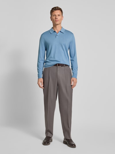 Männermodel trägt Regular Fit Strickpullover aus Woll-Mix von CK Calvin Klein in Blau mit Polokragen, Knopfleiste, Label-Stitching, Gerippte-Abschlüsse, Rückenlänge 68 cm, Ärmellänge 69 cm, Ganzkörperansicht von vorne.