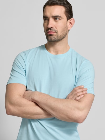 Męski model nosi T-Shirt mit Label-Detail od bugatti, jasnoniebieski kolor, czysta bawełna, prosty krój, okrągły dekolt, długość pleców w rozmiarze M: 69 cm, zbliżenie na górną część ciała z przodu.