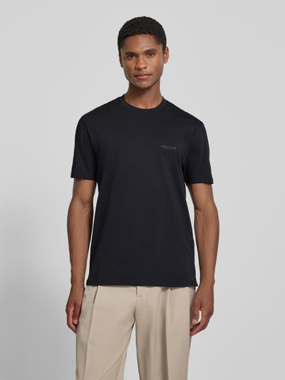 Männermodel trägt Extra Slim Fit T-Shirt mit Rundhalsausschnitt von Armani Exchange in Schwarz mit Logo, Rückenlänge 70 cm bei Größe M, Ganzkörperansicht von vorne.