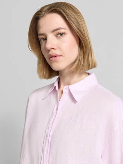 Kobiece model prezentuje Oversize Bluse aus reinem Leinen od Tommy Hilfiger, efekt: jednolity kolor, krój oversized, kształt kołnierza: kołnierzyk koszulowy, aplikacja: wyhaftowane logo, aplikacja z logo, zapięcie: listwa guzikowa, rękawy: długi rękaw, zakończenie rękawów: mankiet, materiał: len, zbliżenie na górną część ciała