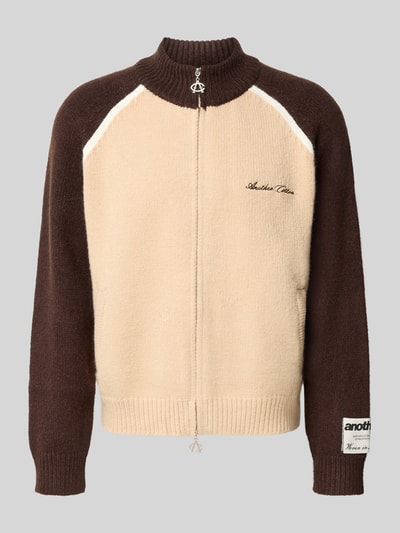Produktfoto, Strickjacke mit Label-Details von ANOTHER COTTON LAB in Beige und Dunkelbraun, gerader Schnitt, Stehkragen, gerippte Abschlüsse, durchgehender Reißverschluss, dezente Textur, Rückenlänge 59 cm, Ärmellänge 70 cm