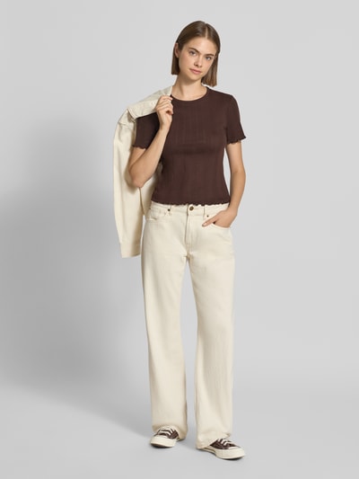 Frauenmodel trägt Slim Fit T-Shirt aus Baumwoll-Mix Modell 'TENNA' von ONLY in Dunkelbraun zu heller Jeans, Ganzkörperansicht von vorne, Damen T-Shirt von ONLY.
