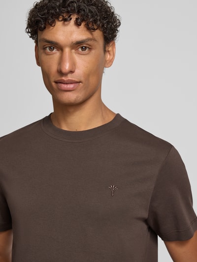 Männermodel trägt T-Shirt mit Logo-Stitching Modell 'Priamo' von JOOP! Collection in Braun, reine Baumwolle, Nahaufnahme Oberkörper.