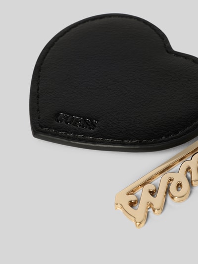 Produktfoto, Schlüsselanhänger in Motiv-Optik von Guess in Schwarz mit Logo-Detail, Leder-Optik und goldenem Karabinerhaken auf grauem Hintergrund