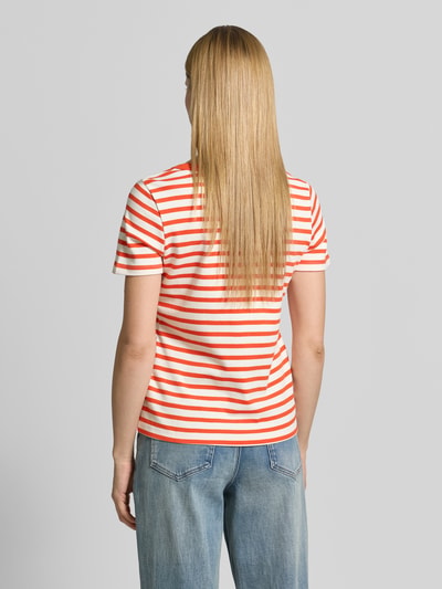 Frauenmodel trägt T-Shirt mit Rundhalsausschnitt und Stitching von Smith and Soul in orange-weißen Streifen, reine Baumwolle, Ganzkörperansicht Rückansicht.