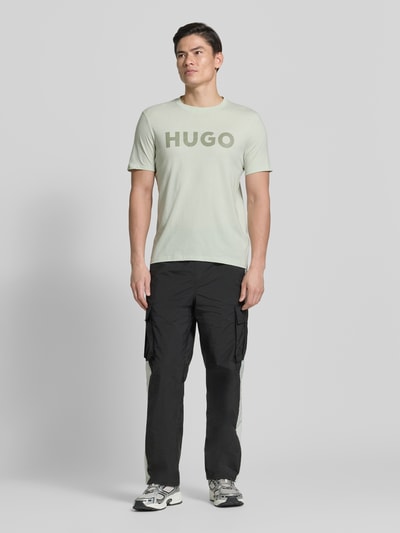 Männermodel trägt Relaxed Fit T-Shirt aus reiner Baumwolle Modell 'DULIVIO' von HUGO, Optik: Unifarben, Label-Schriftzug, Ganzkörperansicht von vorne.