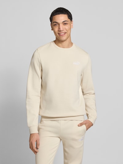 Männermodel trägt Regular Fit Sweatshirt mit Logo-Stitching von PUMA PERFORMANCE in Beige, Baumwoll-Mix, Ganzkörperansicht von vorne.