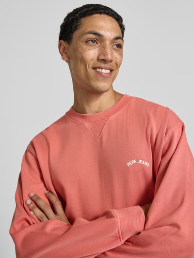 Männermodel trägt Regular Fit Sweatshirt aus reiner Baumwolle Modell 'JOHN CREW' von Pepe Jeans in Rosa, Nahaufnahme Oberkörper, Herren Sweatshirt.