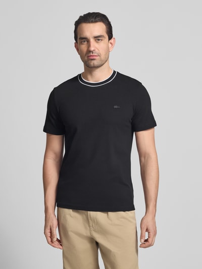 Mannelijk model draagt Regular Fit T-shirt uit katoenmix van Lacoste, look: effen, logostitching, ronde hals, korte mouw, piqué, frontale bovenlichaam close-up.