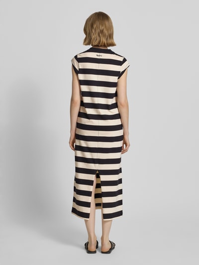 Frauenmodel trägt Fließendes Freizeitkleid aus reiner Baumwolle von Pepe Jeans, Optik:Allover-Muster, Passform fließend, Midi-Länge, Rundhals, Kappärmel, gerade, Materialverarbeitung Jersey, reine Baumwolle, creme und schwarz gestreift, Struktur weich, Ganzkörperansicht Rückansicht.