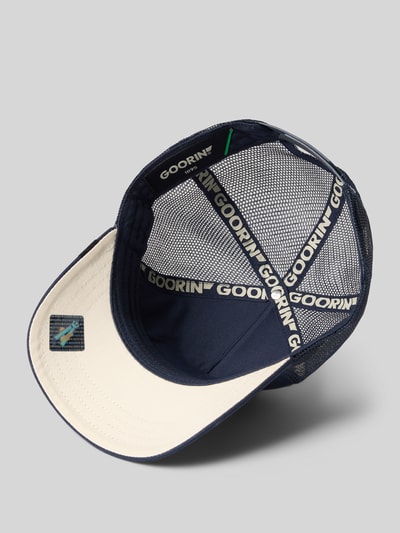 Produktfoto, Trucker Cap mit Motiv-Patch Modell 'bear' von GOORIN BROS., Herren Trucker Cap aus Material-Mix mit Baumwoll-Anteil, verstärkter Schirm, Label-Detail, verstellbarer Riegel an der Rückseite, Farbkombination aus Dunkelblau und Beige, mit Mesh-Detail und Logo-Print im Inneren.