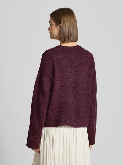 Frauenmodel trägt Relaxed Fit Pullover mit Rundhalsausschnitt Modell 'SIMONI' von ONLY in Dunkellila, Damen Pullover, Ganzkörperansicht Rückansicht.