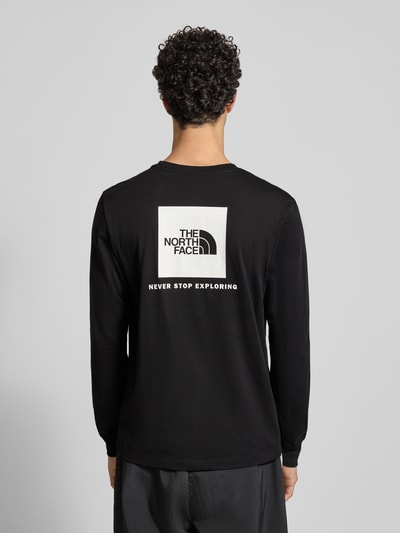 Męski model nosi Regular Fit Longsleeve mit Logo-Print od The North Face, czarny, bawełniany, długi rękaw, krój regular fit, widok całej sylwetki z tyłu.